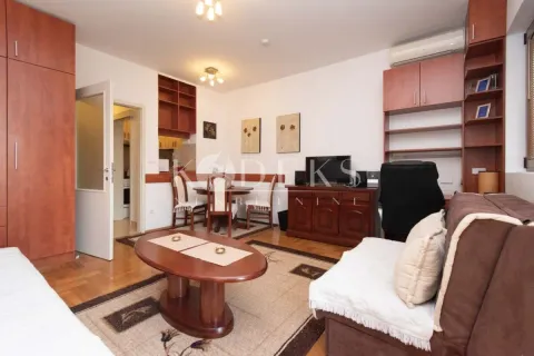Living room with a sofa, TV cabinet, and dining table. - image 3