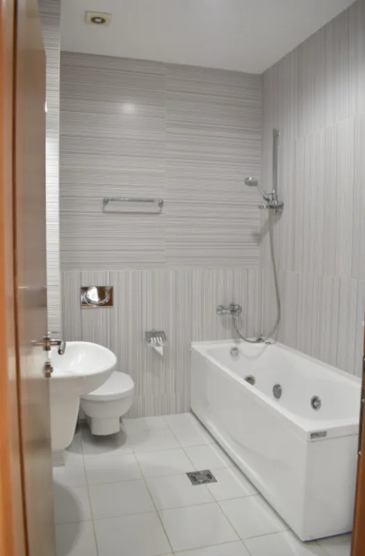 Moderno opremljeno kupatilo sa kadom, umivaonikom i wc šoljom.