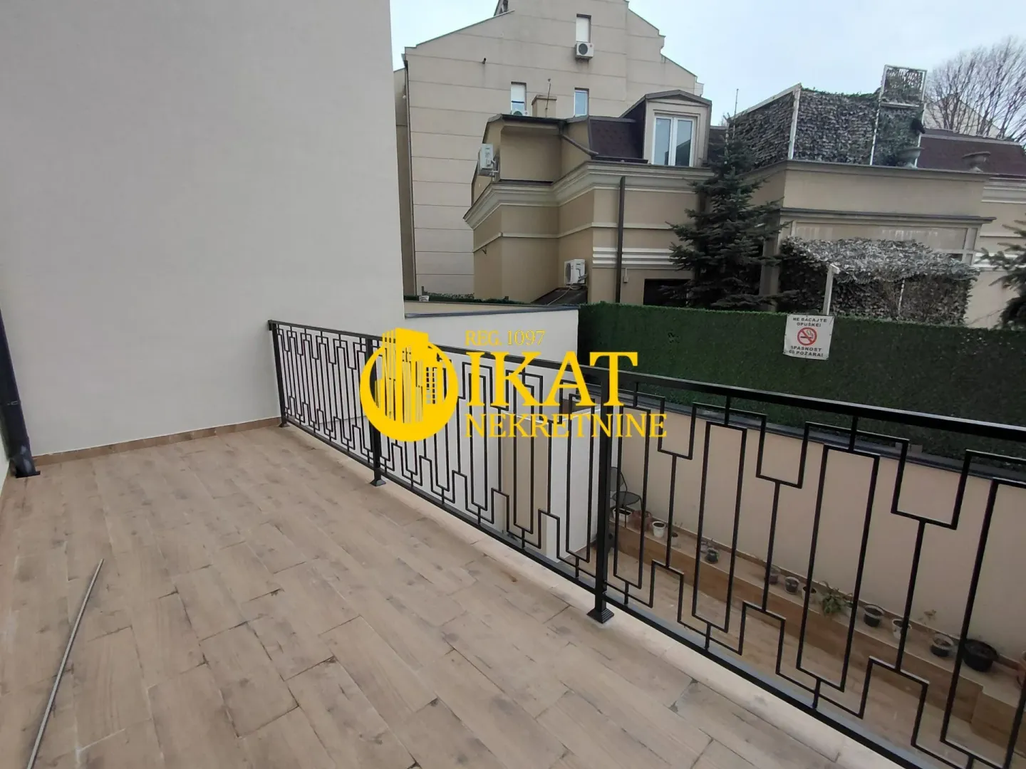 Spacious terrace with wooden flooring and a black railing.