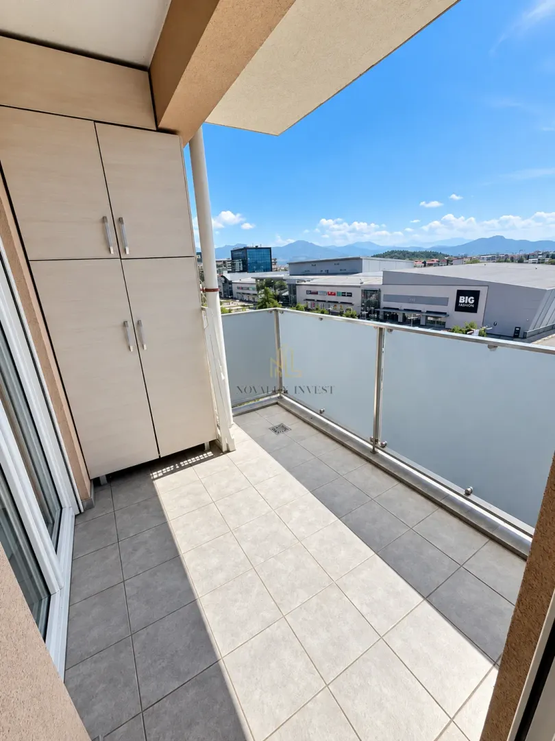 Covered balcony with built-in cabinet and city view.