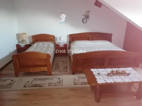 Furnished bedroom with a double bed, a single bed, and a wooden coffee table. - image 26