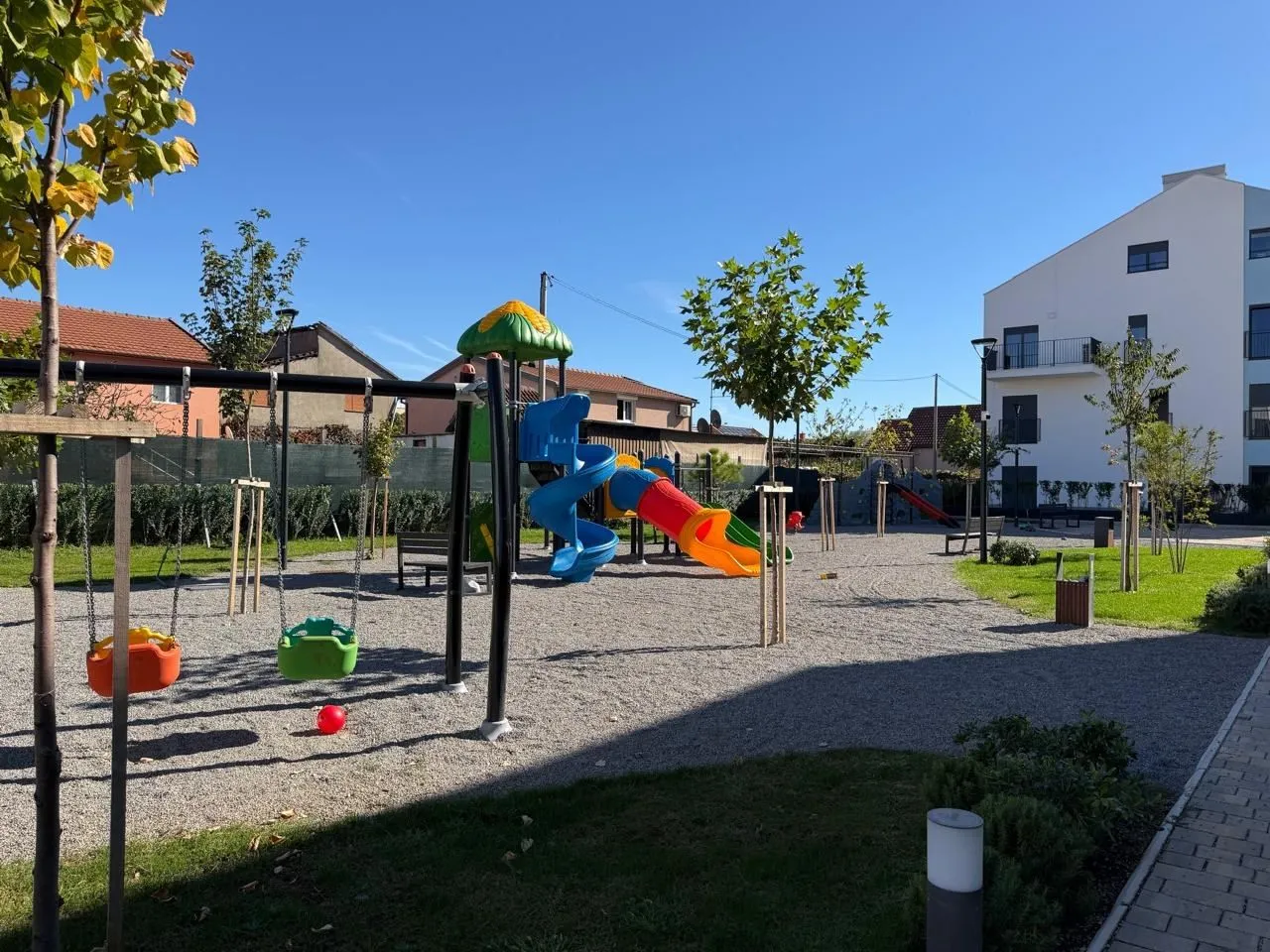 Dvorište sa igralištem ispred stambene zgrade.