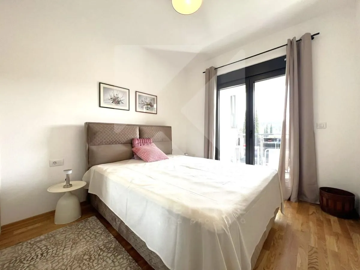 Furnished bedroom with a double bed, parquet flooring, and access to the terrace.