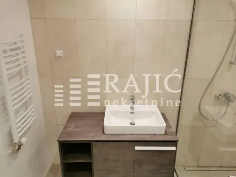 Modern bathroom with a sink vanity and walk-in shower. - image 7