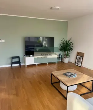 Dnevna soba sa televizorom, drvenim podom i stočićem. - image 10