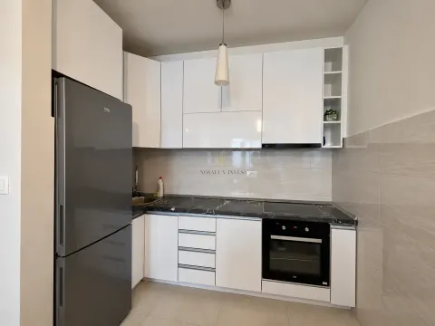White kitchen with black countertops, built-in appliances, and a large refrigerator. - image 5