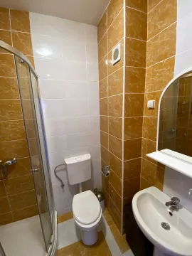 Kupatilo sa tuš kabinom, umivaonikom i toaletom obloženo keramičkim pločicama. - image 4