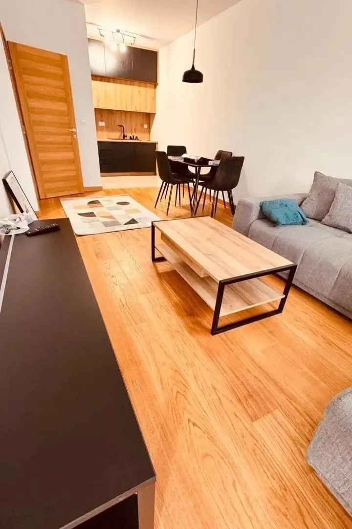 Dnevni boravak sa garniturom, stočićem i trpezarijom u nastavku.