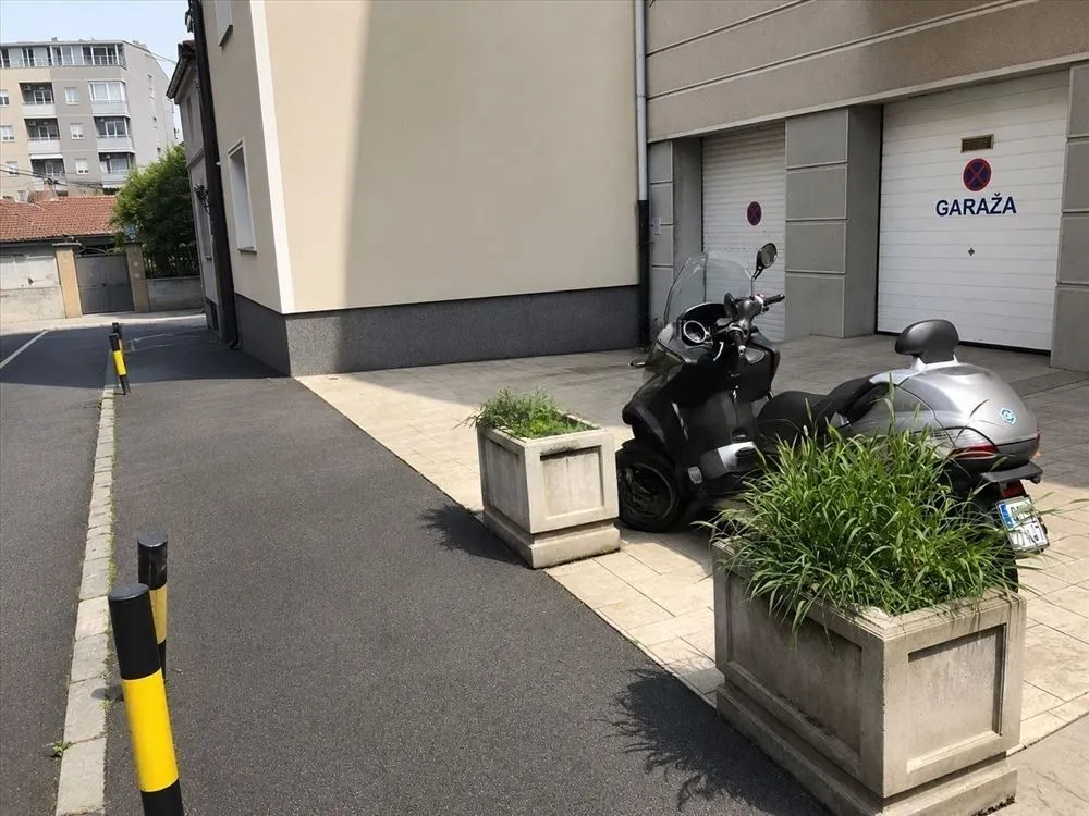 View of the courtyard and garage entrance with a parked scooter.