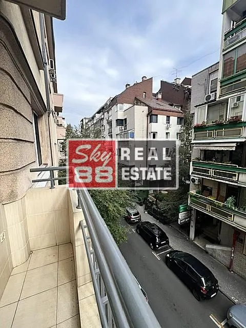 Pogled sa balkona na gradsku ulicu i okolne zgrade.