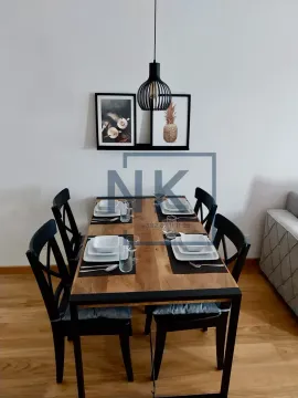 Dining area with a wooden table and black chairs. - image 4