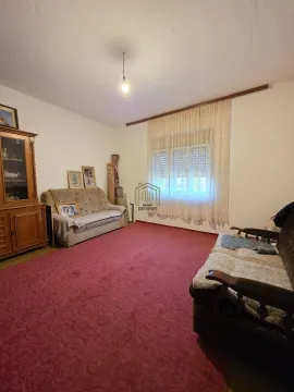 Dnevna soba sa garniturom za sedenje, drvenom vitrinom i prozorom sa zavesama. - image 8