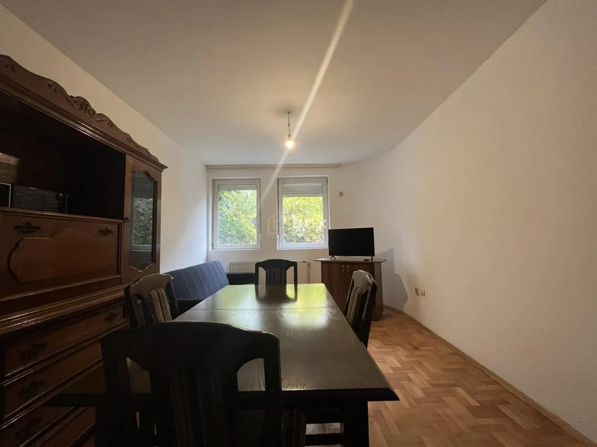 Living room with a dining table, sofa set and parquet flooring.