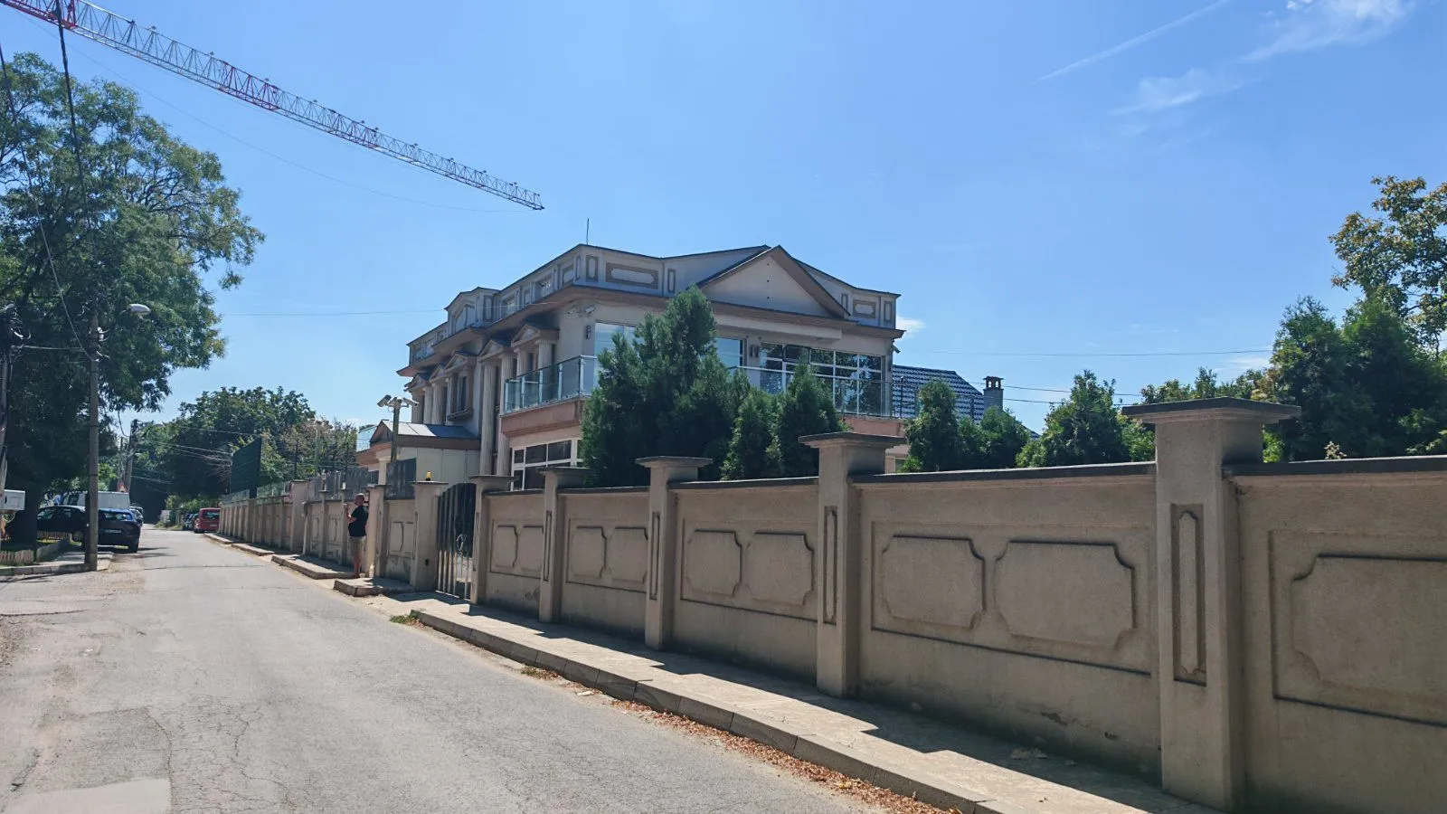 Exterior view of the house with a courtyard and fence.