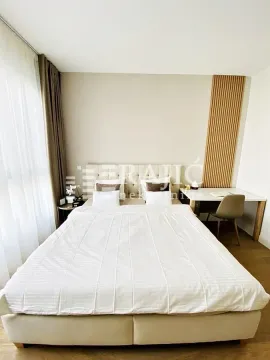 Furnished bedroom with a double bed and a desk. - image 8
