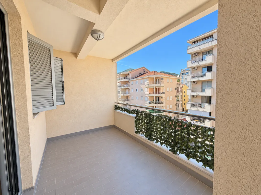 Covered balcony with a view of surrounding buildings and neighborhood.