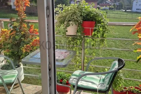 Namešten balkon sa stolom, stolicama i saksijama sa cvećem sa pogledom na prirodu. - image 18