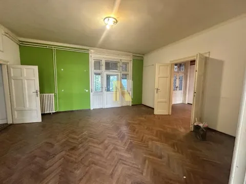 Prazna soba sa drvenim parketom i zelenim zidom. - image 6