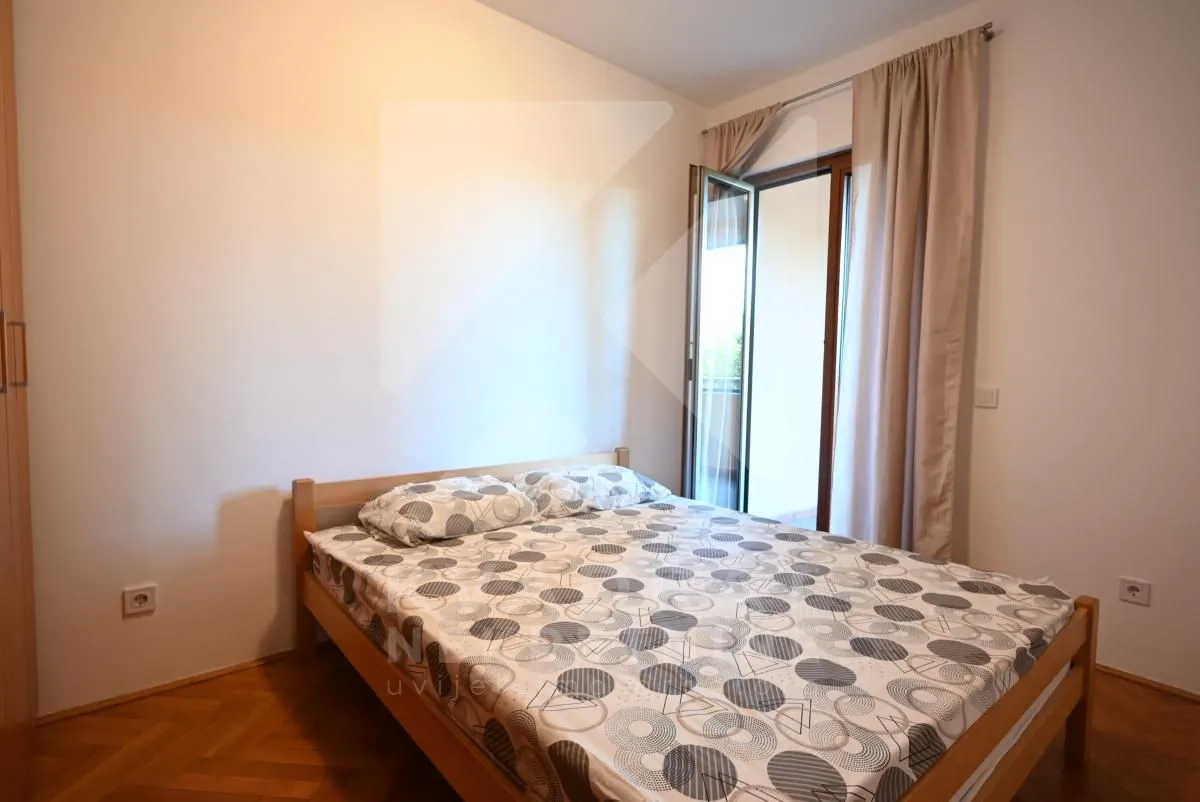 Spavaća soba sa bračnim krevetom i izlazom na terasu.