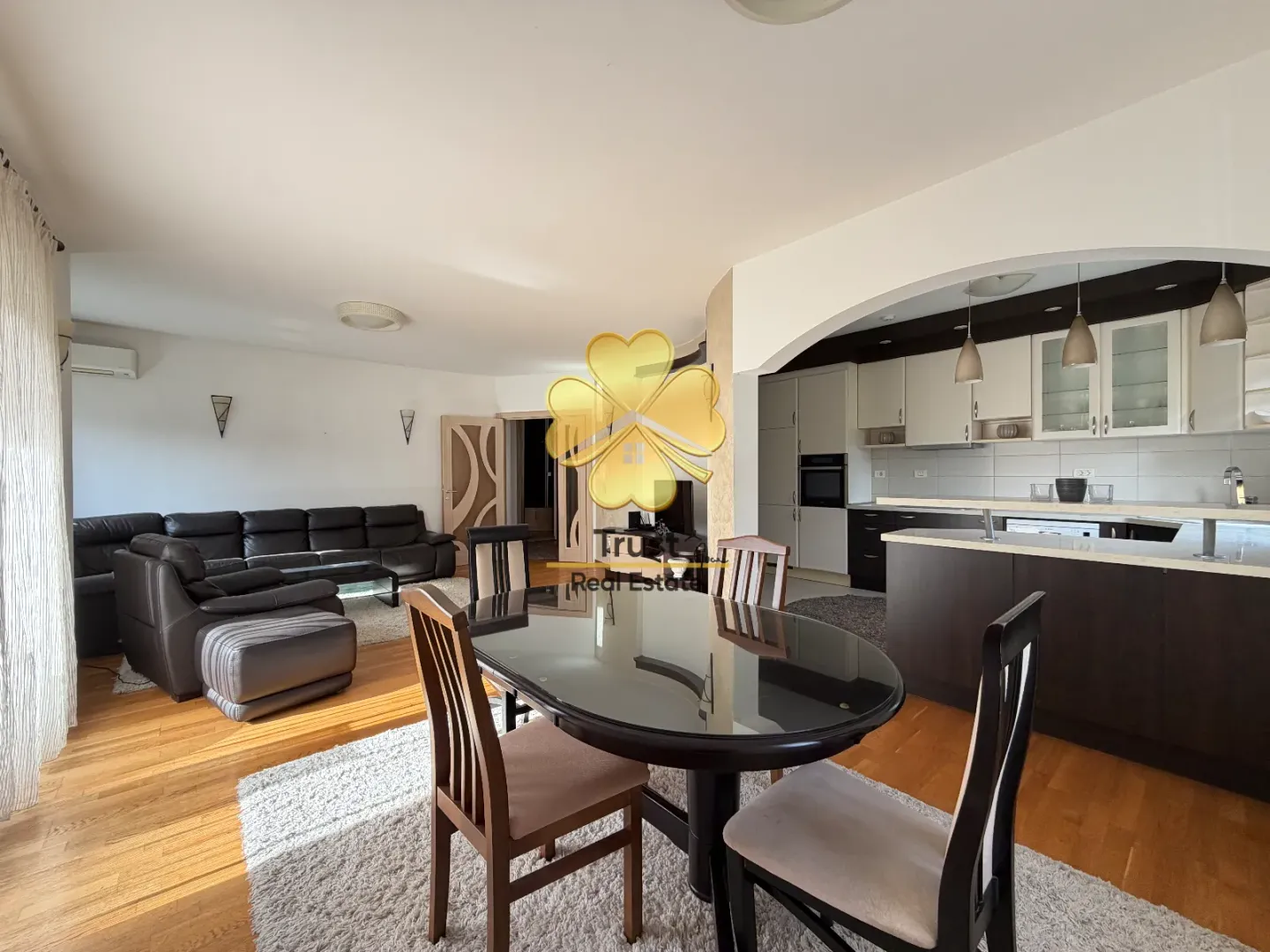 Living room with a dining area and kitchen in the background.