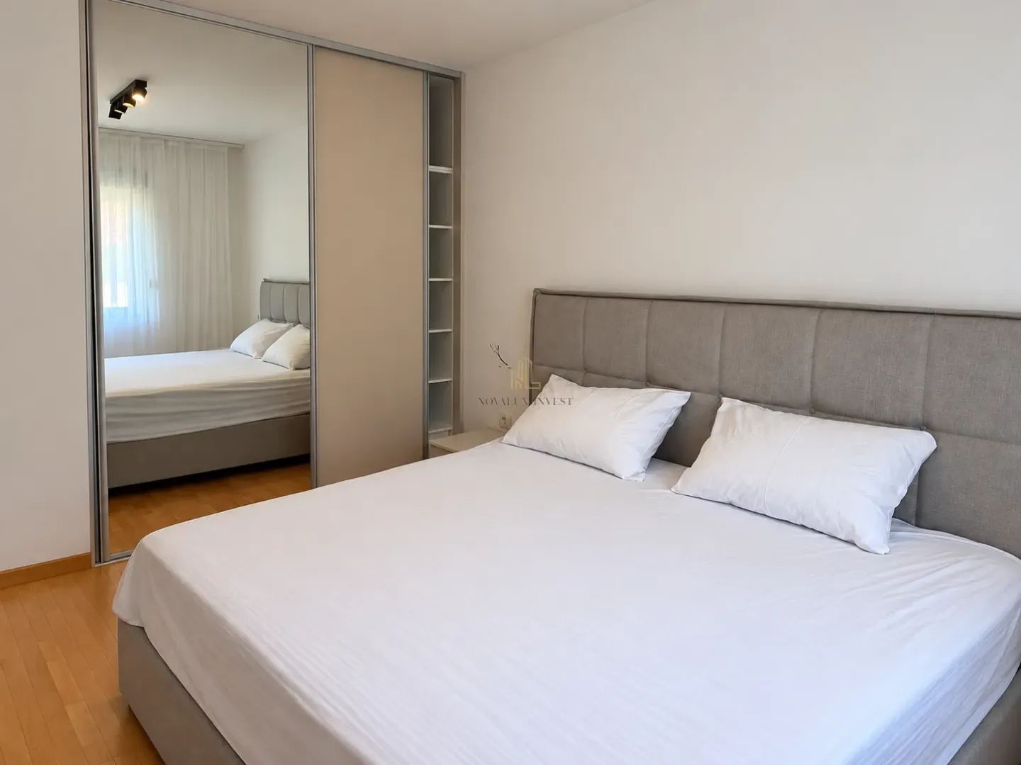 Spacious bedroom with a double bed and a built-in wardrobe with a mirror.