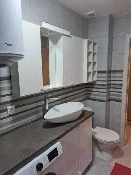 Modern bathroom with a white sink, cabinets, and a toilet. - image 4