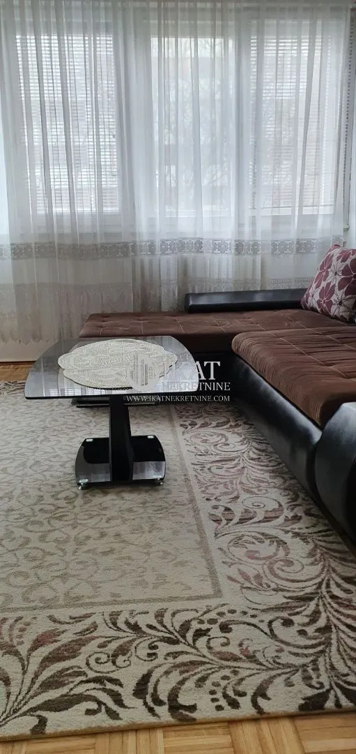 Living room with a corner sofa and a coffee table by the window.