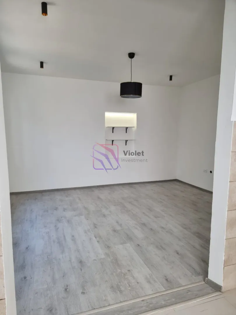 Empty room with laminate flooring and white walls.