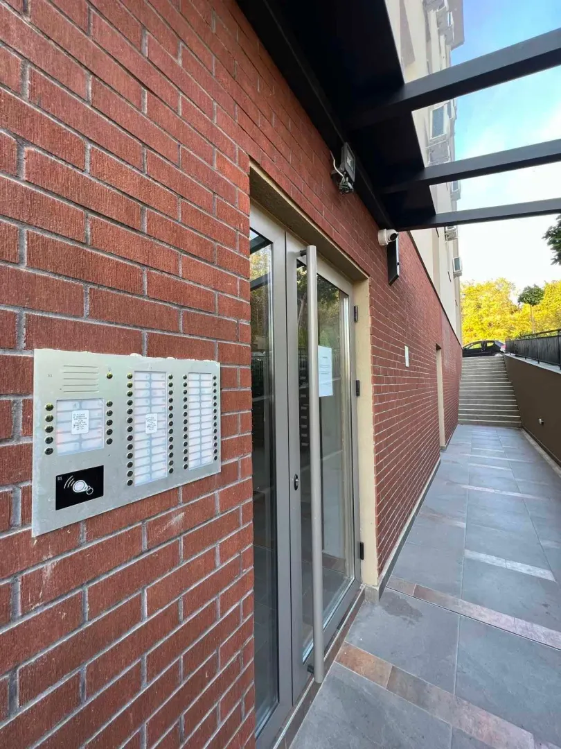 Building entrance with an intercom and stairs.