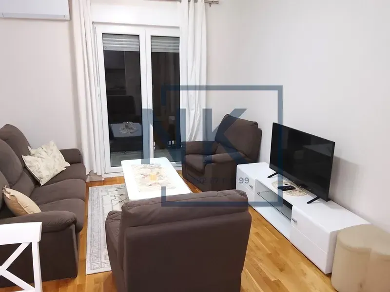 Living room with a sofa set, TV stand and access to the terrace.