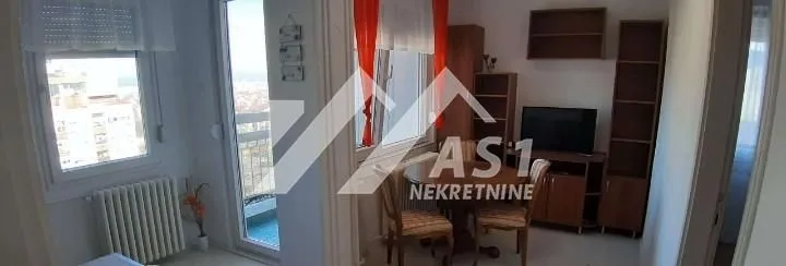 Small living room with a dining table, television, and access to the balcony.