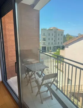 Manji namješten balkon sa garniturom za sjedenje i pogledom na okolne zgrade. - image 11