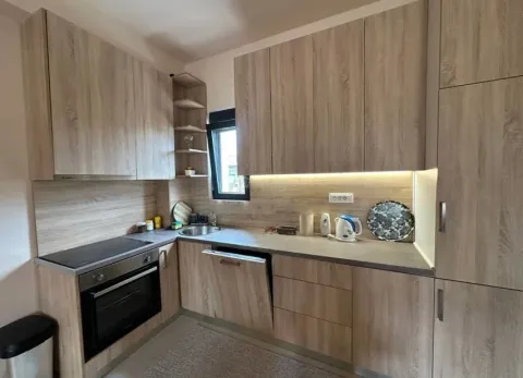 Small kitchen with wooden cabinetry and built-in appliances. - image 9