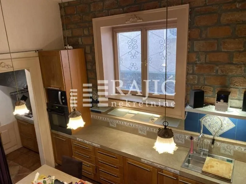 Wooden kitchen with a stone wall and brick details.