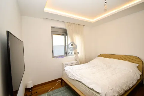 Furnished bedroom with a double bed, window, and a wall-mounted TV. - image 12