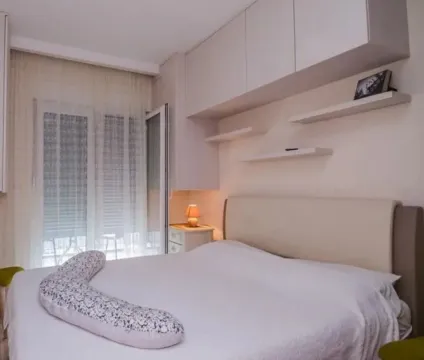 Bright and tidy bedroom with a double bed and wall-mounted cabinets. - image 5
