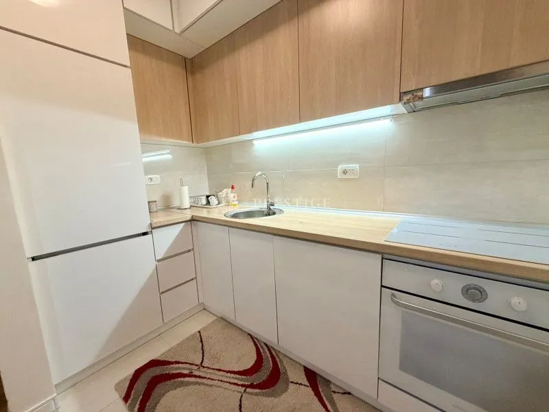 Modern kitchen with white cabinets and wooden countertops.