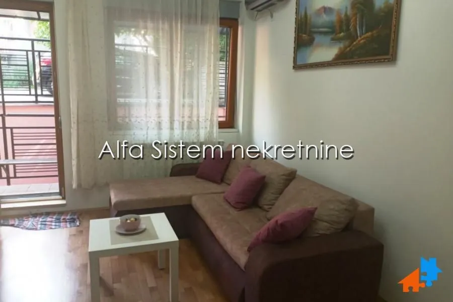 Living room with a sectional sofa, coffee table, and access to the terrace.
