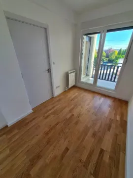 Prazna svetla soba sa drvenim podom i izlazom na balkon. - image 4