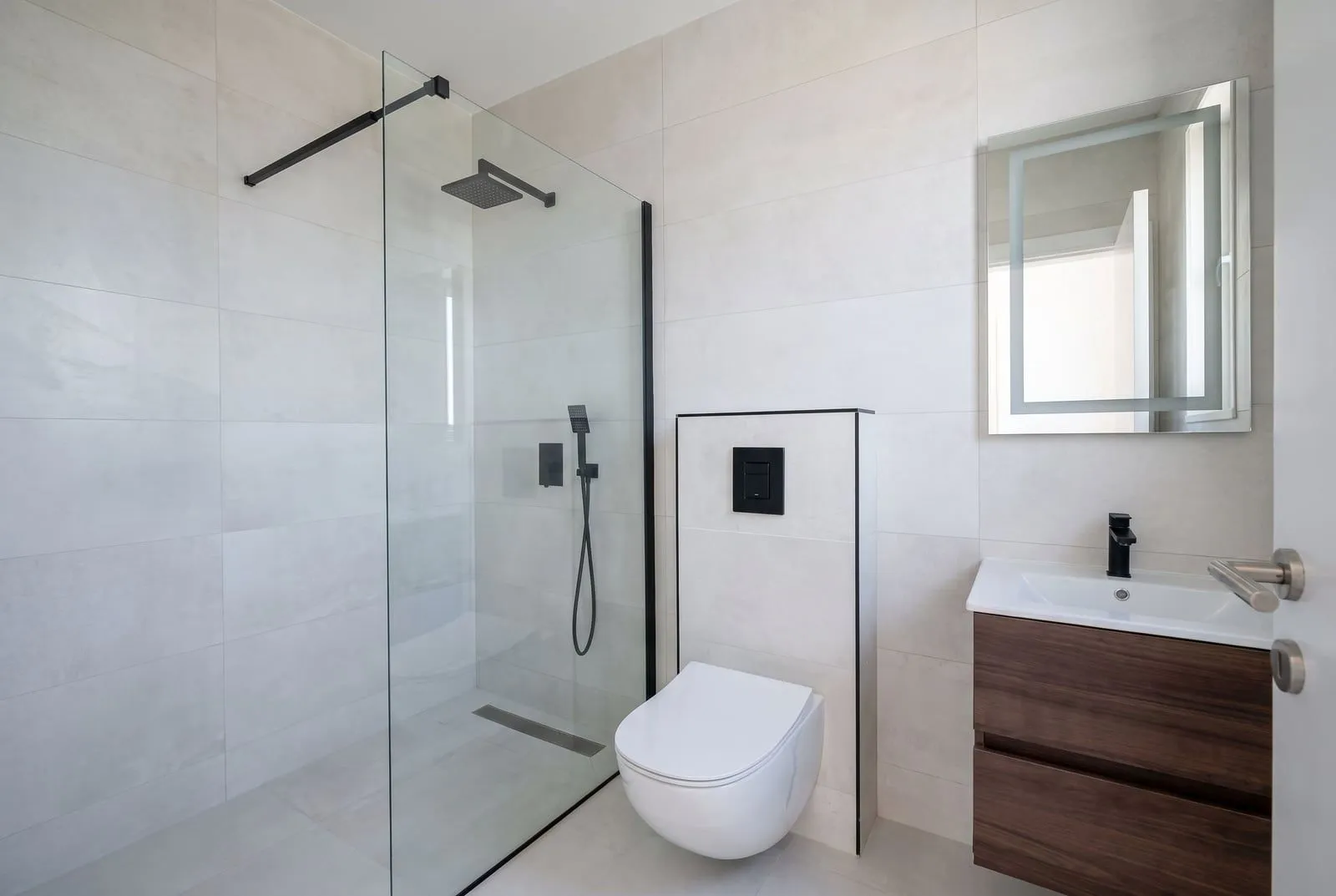 Modern bathroom equipped with a walk-in shower and vanity unit.