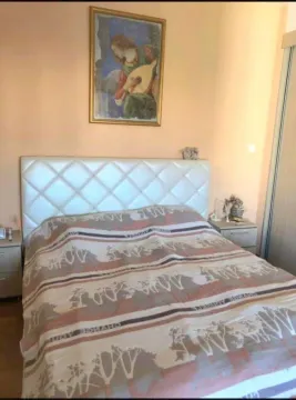 Spavaća soba sa bračnim krevetom, noćnim stočićima i slikom na zidu. - image 8