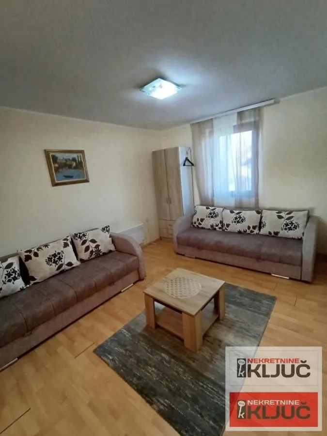 Living room with two sofas, a coffee table, and a window.