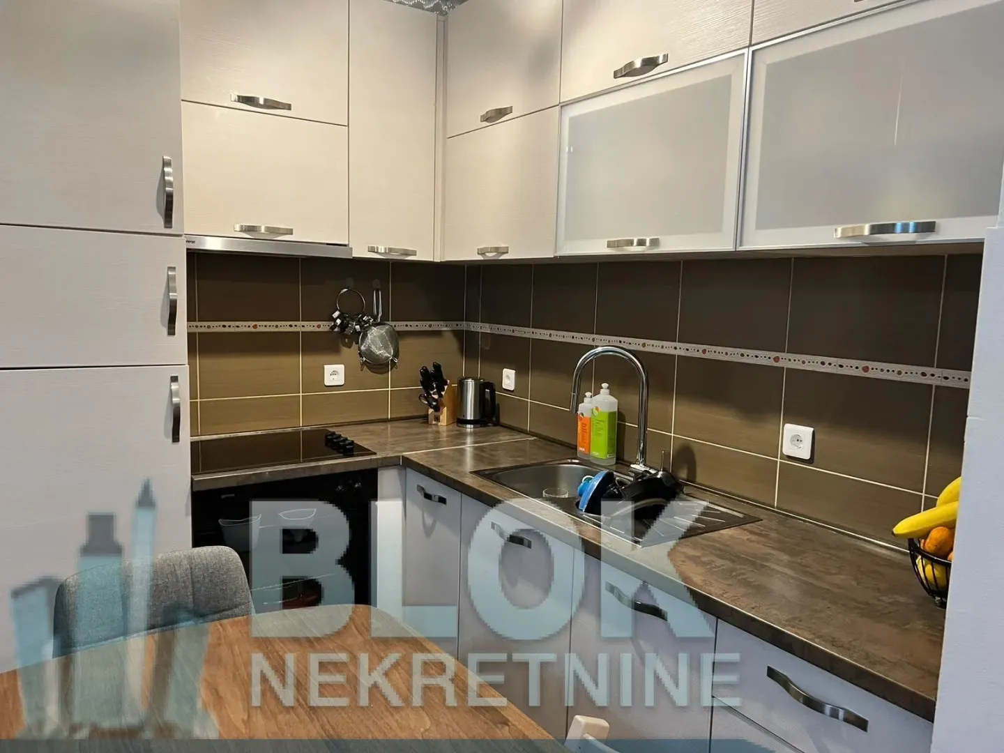 Small equipped kitchen with upper and lower cabinets and a sink.