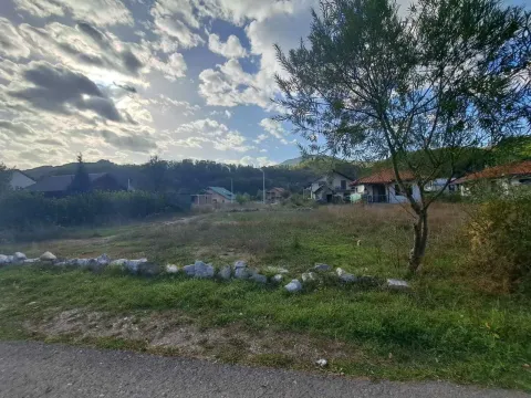 Pogled na prostrani plac sa kućama u pozadini. - image 3
