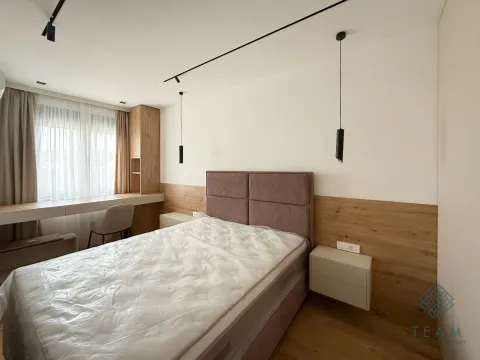 Modern bedroom with a double bed, wooden wall paneling, and a desk. - image 4