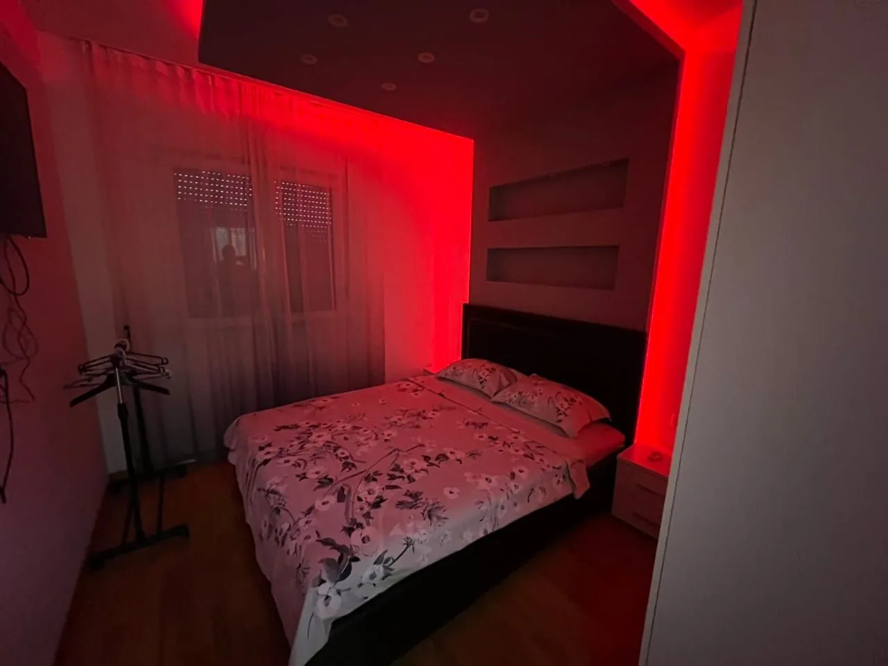 Bedroom with a double bed and red ambient lighting.