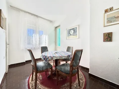 Dining area with a table, four chairs and a rug. - image 10