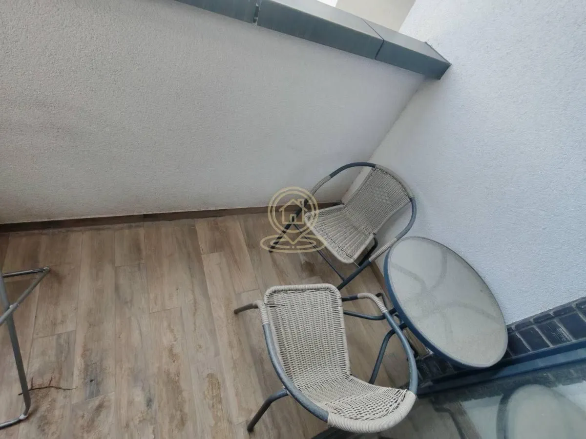 Manji namešteni balkon sa stolom i dve stolice.