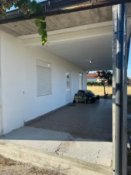 Covered terrace and house entrance with tiled flooring. - image 4