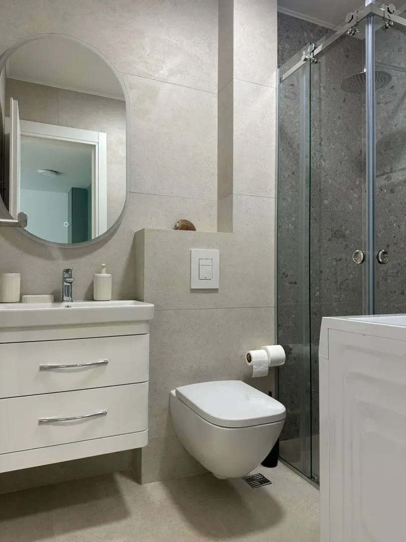 Moderne kupatilo sa umivaonikom, ugradnom wc šoljom i tuš kabinom.